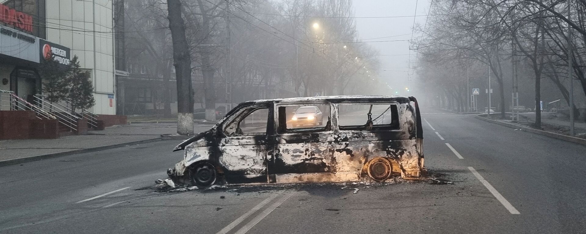 Автомобиль, сожженный во время протестов, вызванных повышением цен на топливо, на дороге в Алматы - Sputnik Таджикистан, 1920, 09.01.2022