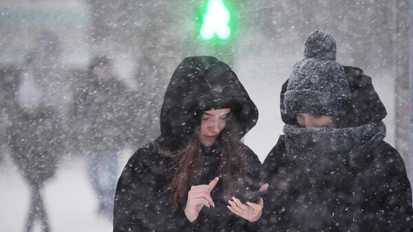 Девушки на улице во время снегопада  - Sputnik Таджикистан
