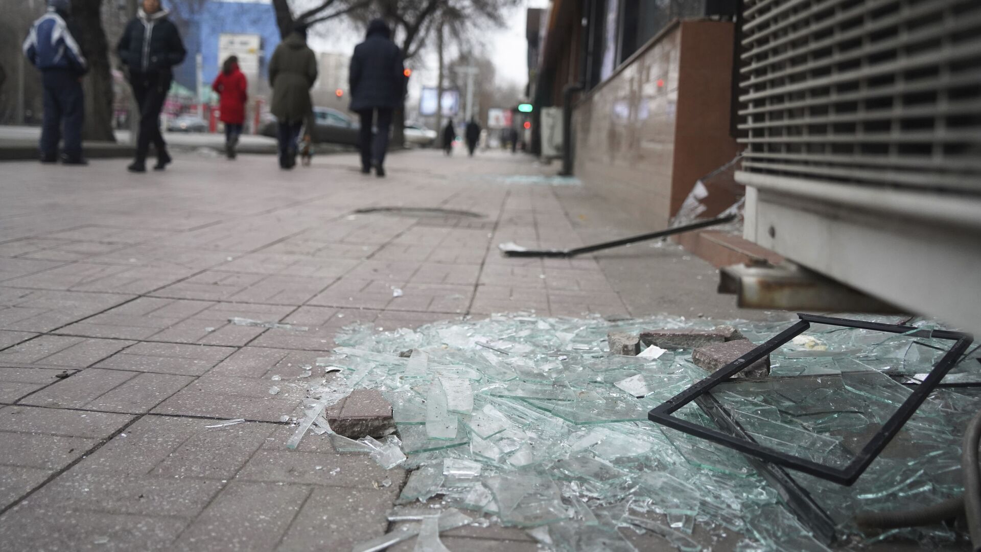 Люди проходят мимо магазина с разбитыми окнами в Алматы - Sputnik Таджикистан, 1920, 11.01.2022