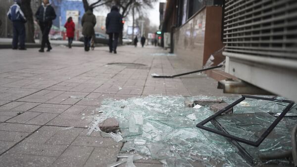 Люди проходят мимо магазина с разбитыми окнами в Алматы - Sputnik Таджикистан