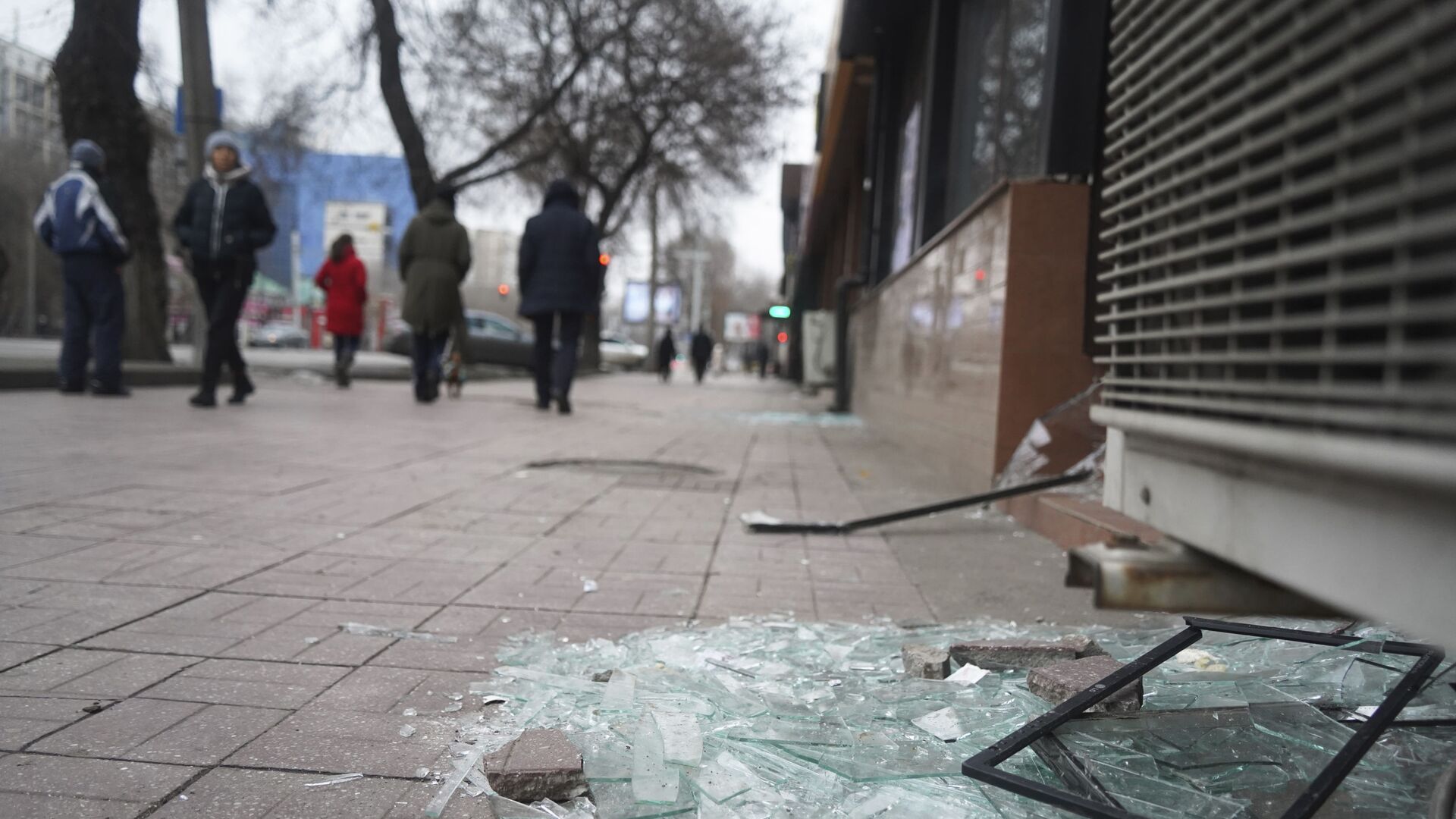 Люди проходят мимо магазина с разбитыми окнами в Алматы - Sputnik Таджикистан, 1920, 13.01.2022