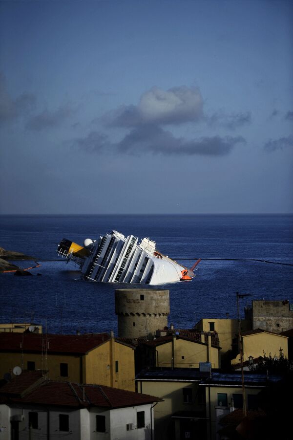 Потерпевший крушение круизный лайнер Costa Concordia у острова Изола-дель-Джильо 23 января 2012 года.  - Sputnik Таджикистан