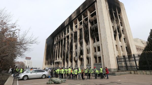 Рабочие во время обеда в перерыве восстановительных работ пострадавшего от пожара здания Акимата в Алма-Ате - Sputnik Тоҷикистон