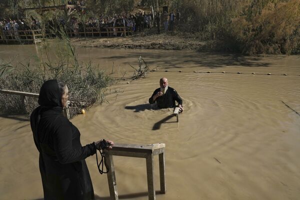 Православный паломник погружается в реку Иордан во время церемонии крещения в день православного праздника Богоявления в Каср-эль-Яхуд, недалеко от города Иерихон. - Sputnik Таджикистан