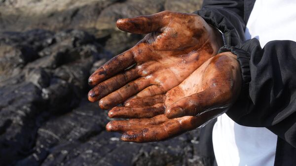 Велосипедист с покрытыми нефтью руками на пляже в Вентанилья, Перу - Sputnik Тоҷикистон
