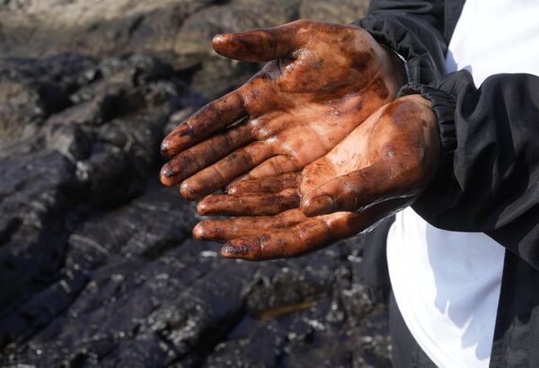 Жители прибрежного перуанского города Вентанилья помогают спасателям собирать нефть. - Sputnik Таджикистан