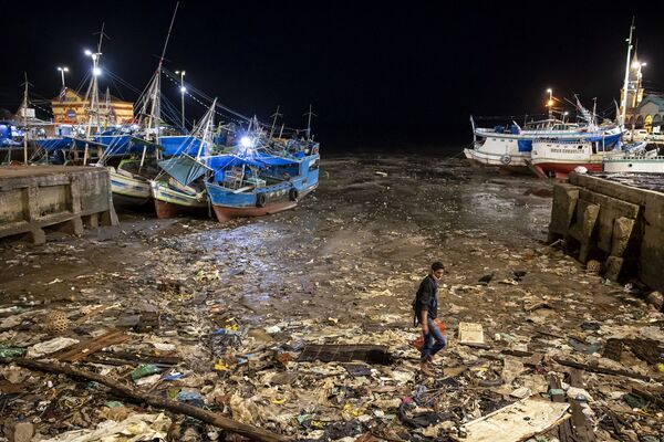 Мужчина пытается найти что-то ценное в гавани, обнажившей мусор после отлива. Белем, Бразилия. - Sputnik Таджикистан