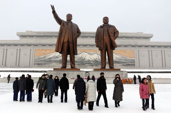 Жители Северной Кореи и туристы пришли к памятникам бывших лидеров страны Ким Ир Сена и Ким Чен Ира на холме Мансу в Пхеньяне. - Sputnik Таджикистан