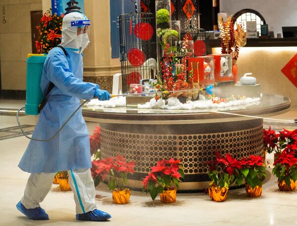 Сотрудник эпидемиологической службы обрабатывает отель в олимпийской зоне после эвакуации постояльца с COVID-19 в Пекине. - Sputnik Таджикистан