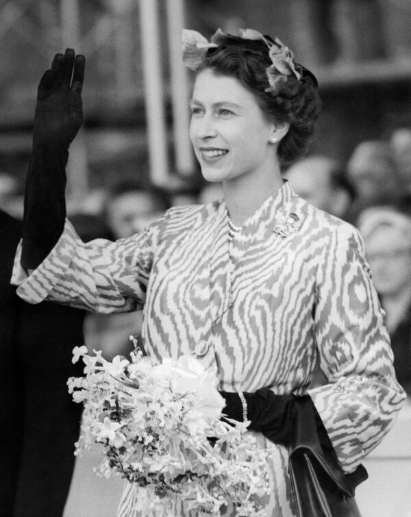 Королева Елизавета II машет рукой, когда канадский тихоокеанский лайнер &quot;Императрица Британии&quot; выходит на воду в Глазго, 22 июня 1955 года. - Sputnik Таджикистан