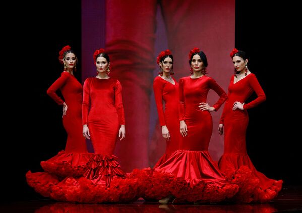 Классический красный цвет в новой коллекции звучит по-прежнему модно и страстно. Для этого дизайнеры немного &quot;перефразировали&quot; силуэт традиционного платья, сделав его более приталенным. - Sputnik Таджикистан