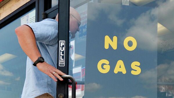 Покупатель заходит на заправочную станцию ​​Exxon и в магазин, где на двери висит табличка Без газа - Sputnik Таджикистан