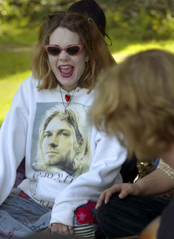 Фанатка Курта Кобейна исполняет песни Nirvana в 10-ю годовщину смерти музыканта. Она поет в парке рядом с домом, где он совершил самоубийство 10 лет назад, 2004. - Sputnik Таджикистан