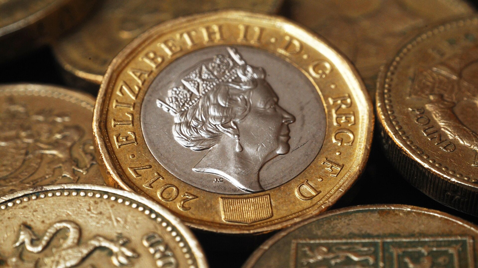 Монеты Великобритании номиналом один фунт стерлингов с портретом королевы Елизаветы Второй. - Sputnik Таджикистан, 1920, 20.02.2022