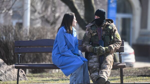 Военнослужащий с девушкой в одном из скверов в Донецке - Sputnik Тоҷикистон