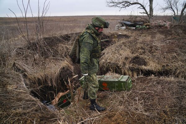Военнослужащий народной милиции ДНР осматривает брошенные украинской армией противотанковые комплексы - Sputnik Таджикистан