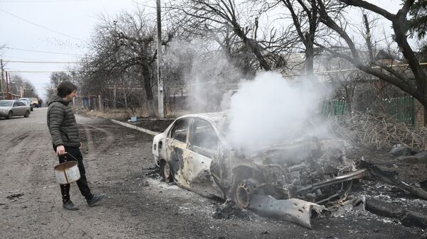 Мужчина у горящего автомобиля в Донецке  - Sputnik Таджикистан