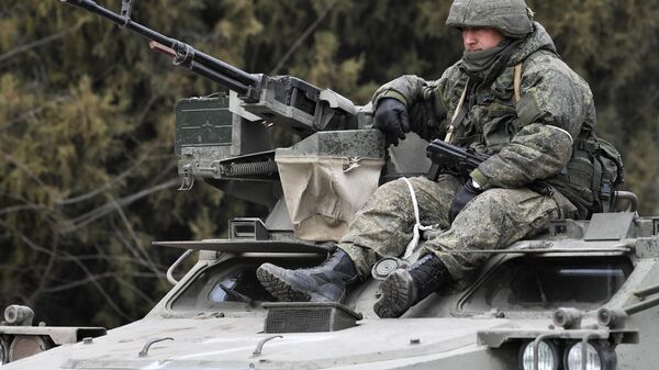 Российский военнослужащий в колонне военной техники на шоссе возле границы с Украиной в Армянске - Sputnik Таджикистан