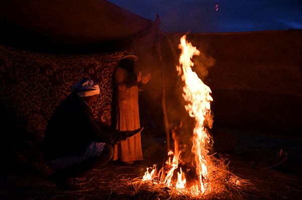 Семья кочевников-бедуинов собирается у костра после сильного ливня. - Sputnik Таджикистан