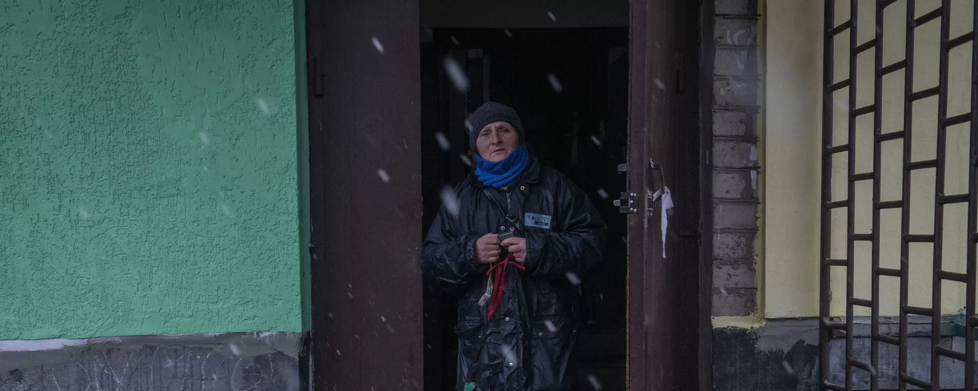 Женщина выходит из подъезда жилого дома в освобожденном городе Счастье в Луганской народной республике - Sputnik Тоҷикистон, 1920, 16.04.2022
