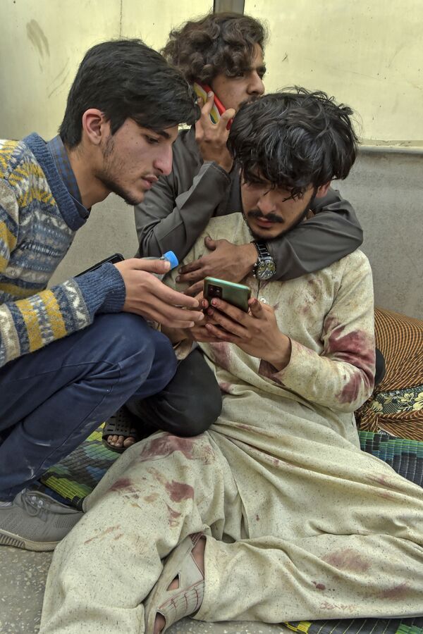 Раненый мужчина пытается связаться с родственниками после теракта. - Sputnik Таджикистан