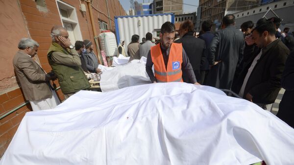 Люди собираются вокруг тел жертв взрыва бомбы возле больницы в Пешаваре, Пакистан - Sputnik Тоҷикистон