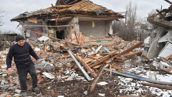 Житель села Сопино в Донецкой народной республике у одного из разрушенных домов - Sputnik Тоҷикистон
