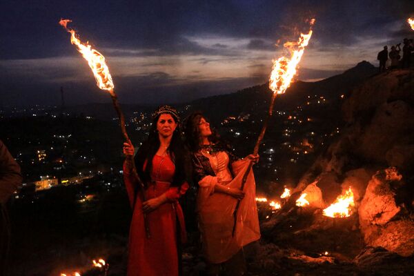 Иракские курды несут факелы во время празднования Навруза, праздника, посвященного первому дню весны в городе Акра недалеко от Духока в Ираке. - Sputnik Таджикистан