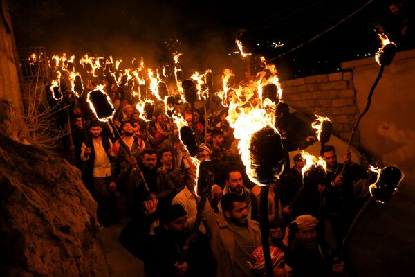 Иракские курды несут зажженные факелы во время празднования Навруза. - Sputnik Таджикистан