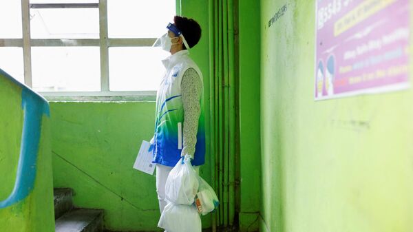 Волонтер держит противоэпидемические пакеты, доставляя их жителям во время пандемии коронавируса в Гонконге - Sputnik Таджикистан