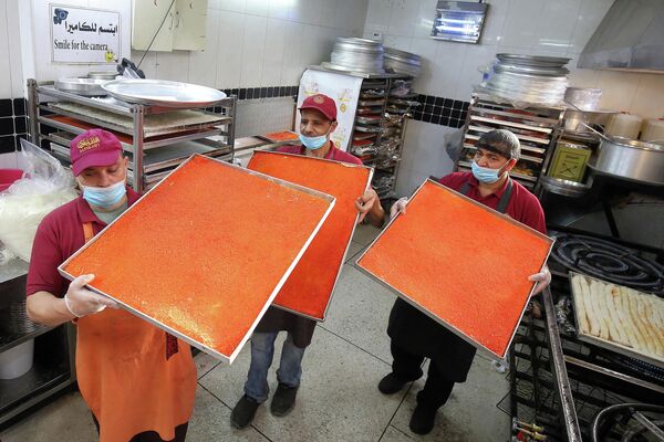 Работники питания выносят подносы с кунафой в Кувейте. - Sputnik Таджикистан