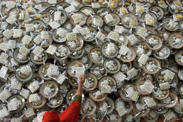 Женщина подготавливает бесплатные наборы с едой для верующих в Индонезии.  - Sputnik Таджикистан