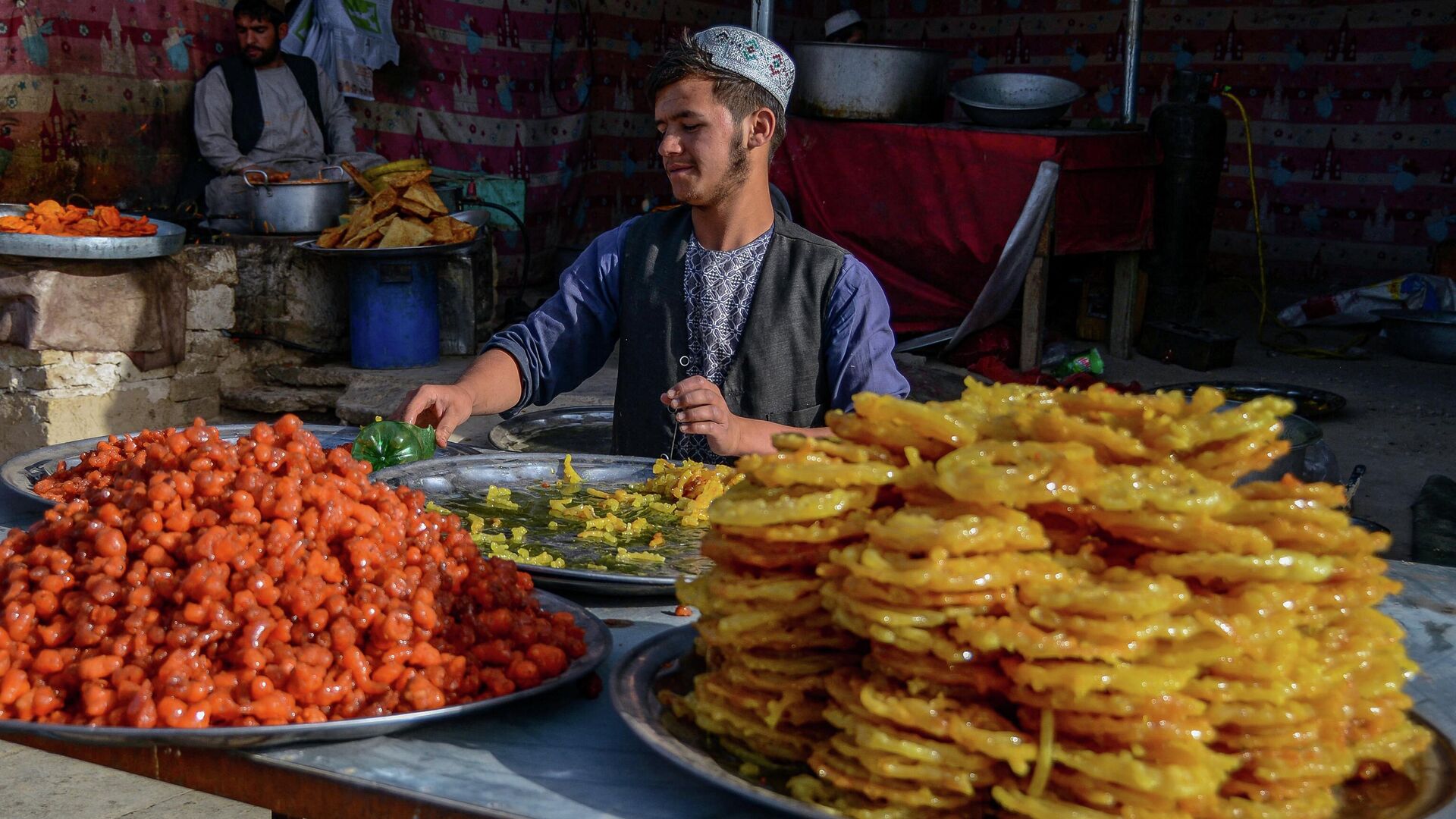   Продавец сладостей ждет покупателей в первый день священного месяца поста Рамадан в Кандагаре - Sputnik Таджикистан, 1920, 01.05.2022