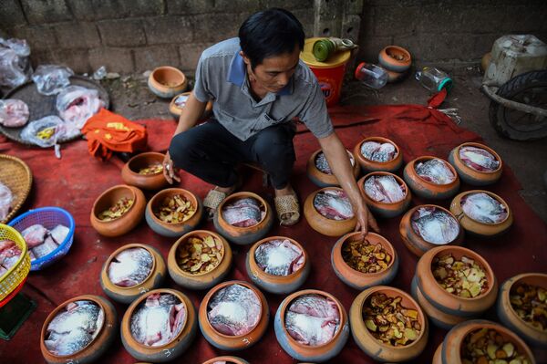 Мужчина готовит еду в глиняных горшках во вьетнамской провинции Ханам. - Sputnik Таджикистан