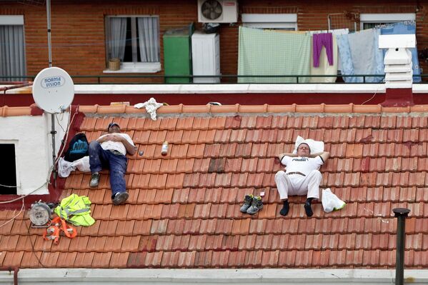 Рабочие дремлют на крыше дома в Мадриде. - Sputnik Таджикистан