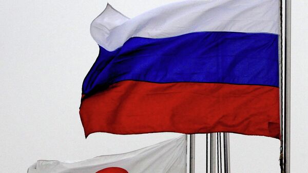 Государственные флаги России (справа) и Японии  - Sputnik Таджикистан