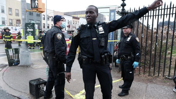 Полиция и сотрудники службы экстренной помощи собираются на месте сообщения о расстреле нескольких человек за пределами станции метро 36 St 12 апреля 2022 года в Бруклинском районе Нью-Йорка - Sputnik Тоҷикистон