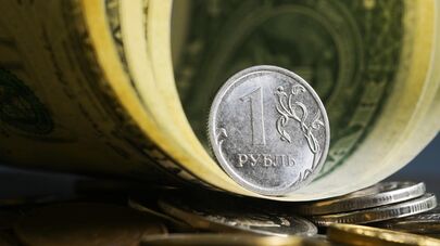 Денежные купюры США и монеты номиналом один рубль.