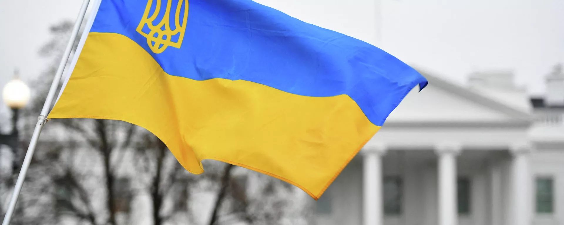 Флаг Украины с гербом развевается, когда активисты собираются на площади Лафайет в знак протеста против российского вторжения в Украину в Вашингтоне - Sputnik Тоҷикистон, 1920, 04.07.2022