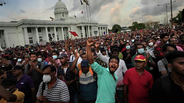 Члены оппозиционной политической партии Шри-Ланки Национальная народная власть выкрикивают антиправительственные лозунги во время митинга протеста в Коломбо - Sputnik Таджикистан
