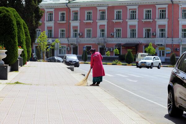 Муниципальный работник Душанбе подметает улицы от пыли и грязи. - Sputnik Таджикистан