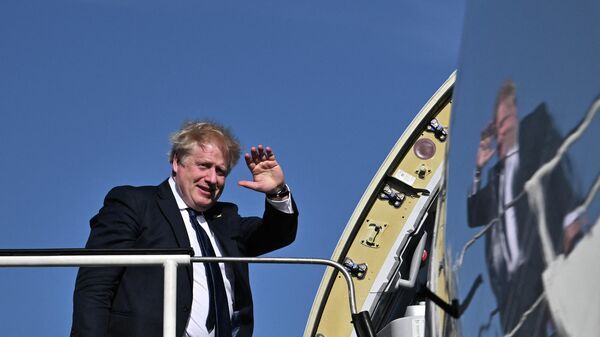 Премьер-министр Великобритании Борис Джонсон машет рукой, садясь в самолет - Sputnik Таджикистан