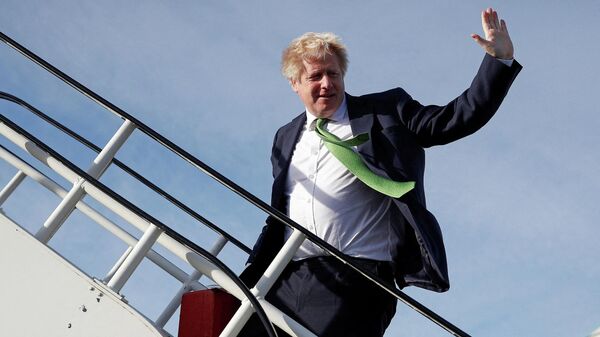 Премьер-министр Великобритании Борис Джонсон машет рукой, садясь в самолет - Sputnik Таджикистан