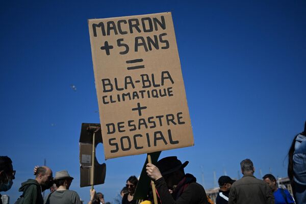 Протестующий держит плакат во время ежегодного Первомая в Марселе. - Sputnik Таджикистан