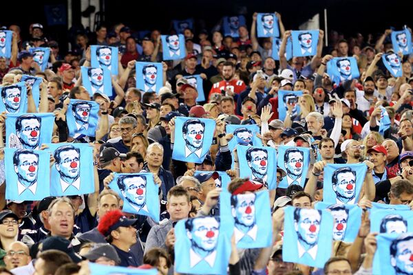 Болельщики держат полотенца с изображением комиссара НФЛ Роджера Гуделла с клоунским носом во время игры между американскими футбольными командами Kansas City Chiefs и New England Patriots. - Sputnik Таджикистан