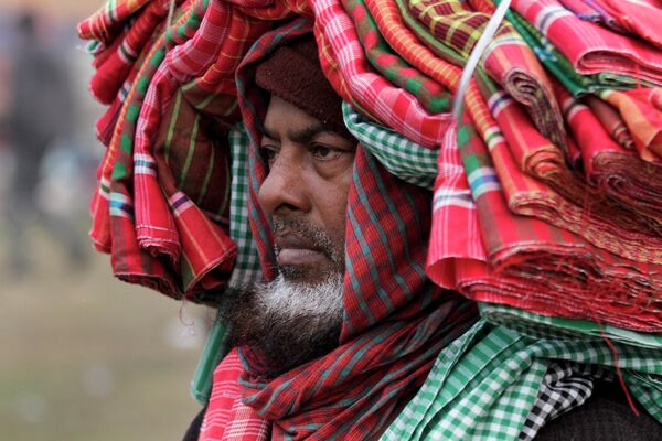 Индийский продавец полотенец ручной работы местного производства ждет покупателей в Калькутте. - Sputnik Таджикистан