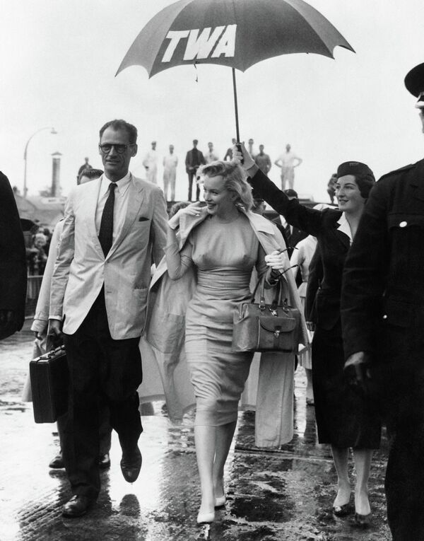 Мэрилин Монро с мужем, американским драматургом Артуром Миллером (слева), 14 июля 1956 года в лондонском аэропорту. - Sputnik Таджикистан