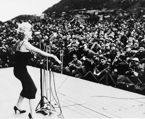 Мэрилин Монро поет перед солдатами во время первого шоу тура по Корее, 22 февраля 1954 года. - Sputnik Таджикистан