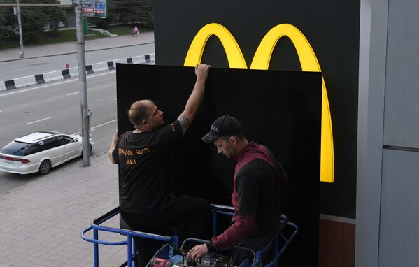 Закрытие вывески ресторана быстрого питания McDonald's на фасаде здания в Новосибирске - Sputnik Таджикистан