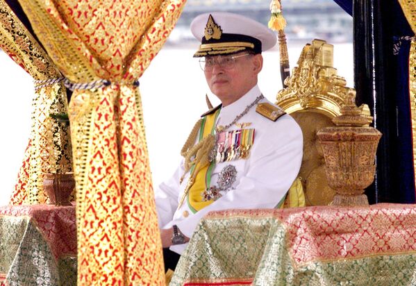 Король Таиланда Пхумипон Адульядет сидит в барже на реке Чао Прайя в Бангкоке, 4 ноября 1999 года. - Sputnik Таджикистан